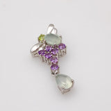 Dije de plata con gemas naturales verdes y moradas sobre fondo blanco - Rocas & Cristales