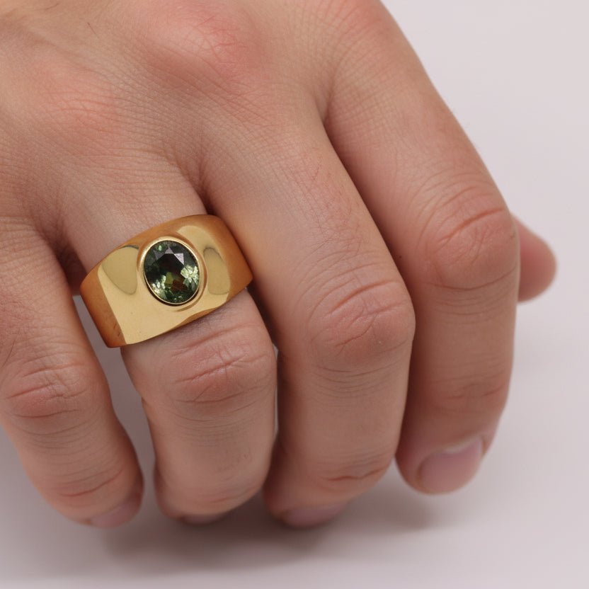 Anillo de Moldavita en Oro 18K con facetado oval y engaste artesanal sobre fondo neutro - Anillos