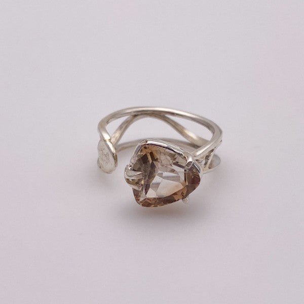 Anillo de Topacio Imperial en Plata 950 con diseño ajustable y gema triangular sobre fondo neutro.- Anillos
