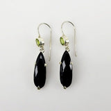 Aros de Ónix y Peridoto en Plata 950 con lágrima negra facetada y peridoto verde superior sobre fondo neutro. - Aros