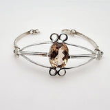 Pulsera de Topacio Imperial en Plata 950 con diseño de triple banda y corte oval sobre fondo neutro - Pulseras